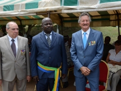 J.Pierre Fourès, Président des sections de l'étranger de l'Ordre National du Mérite et Pierre Grosjean, Président de la section Gabonaise, entourant le Maire de Cocobeach.